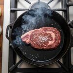 Cast-iron pan with beef tallow, lard, ghee, and butter—top carnivore diet cooking fats.